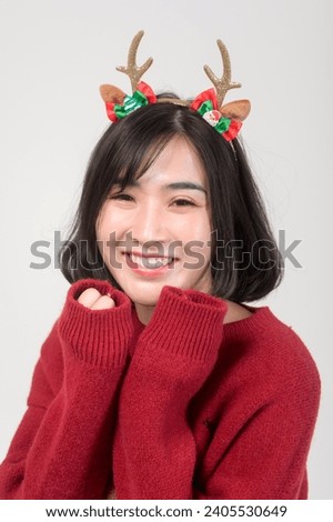 Young happy woman in santa claus hat wearing red sweater over white background, Christmas concept	
