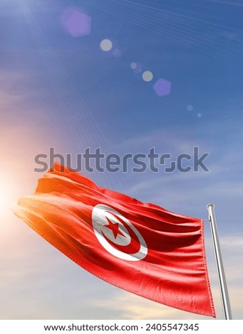 Tunisia national waving flag in vertical beautiful sky. Royalty-Free Stock Photo #2405547345