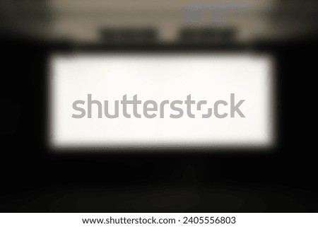 Texture background Abstract blur luxury image of Large projector screen or Cinema theater screen in front of seat rows in movie theater showing white screen projected for executive meeting rooms.