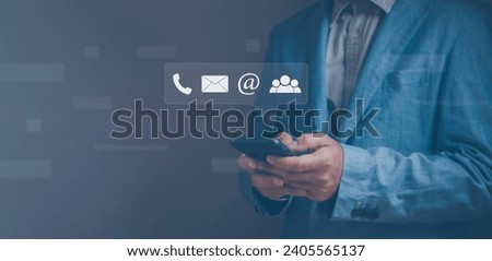Concept of Contact us, or customer hotline service . Businessman using telephone illustrated with icons email, address, phone and people For connecting or supporting online marketing services.