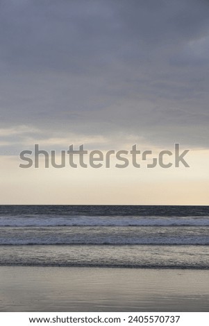 Tranquil ocean coastline with blue sky and gentle waves on sand. natural seashore background