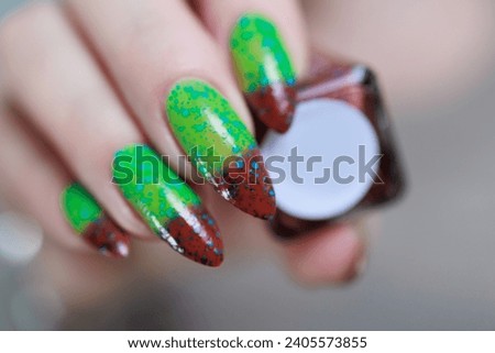 Female hands with long nails and green and brown thermo manicure	