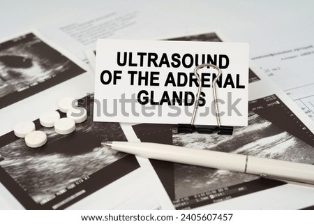 Medical concept. On the ultrasound pictures there is a pen and a business card with the inscription - Ultrasound of the adrenal glands
