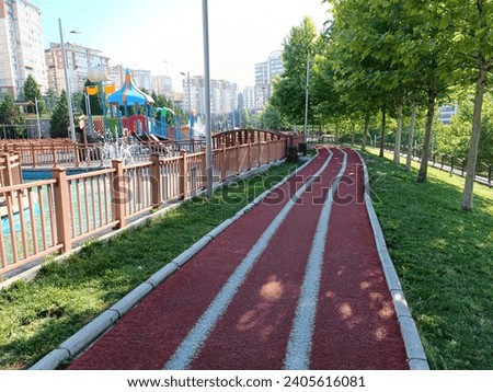 Red treadmill on the street in the park among the trees in the morning. Red running track in the park in summer. walking field