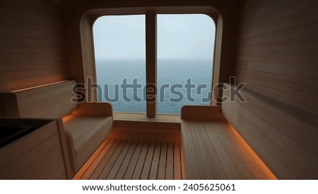 A cozy wooden sauna with a large window overlooking the sea in Antarctica, creating a contrast between the warm interior and the cold exterior.