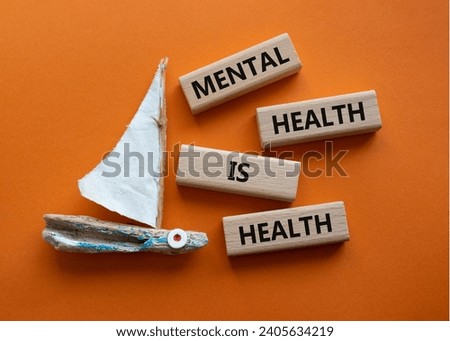 Mental Health symbol. Wooden blocks with words Mental Health is Health. Beautiful orange background with boat. Medical and Health concept. Copy space.