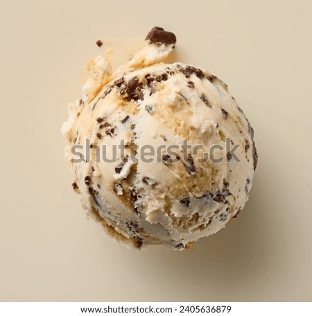 coffee liqueur ice cream scoop with chocolate pieces on beige color background, top view