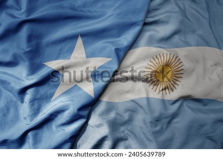 big waving national colorful flag of argentina and national flag of somalia . macro