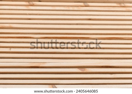 Stack of lumber of a wooden board from a tree, close-up, background. Wooden boards at the sawmill, carpentry workshop. Sawing and air drying of wood. Woodworking industry. Wooden boards.