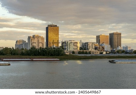 Sunset over the river barges and boats in Mississippi river to skyline of Baton Rouge, the state capital of Louisiana Royalty-Free Stock Photo #2405649867