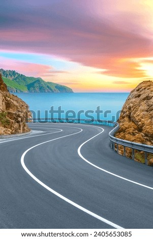 Road landscape at colorful sunset on the beach. Beautiful nature scenery with summer holiday travel on highway between sea and green mountains. Turkey trip on beautiful travel road in Mediterranean.