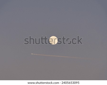Full moon with airplane crossing