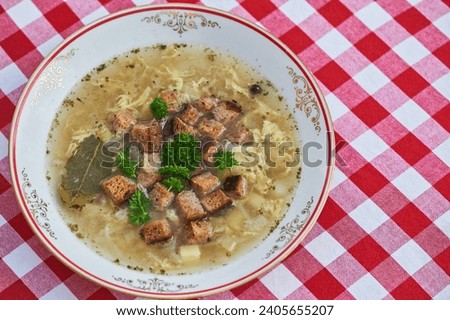 Close up picture of delicious and healthy garlic soup, dish from cuisine of Czech republic made from beef broth, potatoes, eggs and fresh garlic, served with parsley and bread crums mainly in winter.