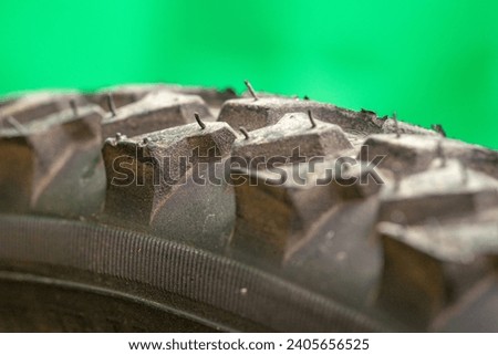 detail of a black bicycle tire with fur on the surface. green background