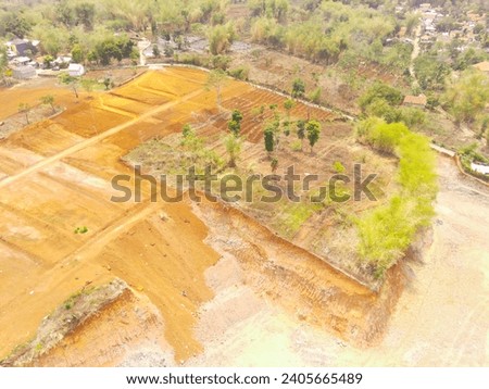 Industrial Photography. Aerial Landscapes. Dredged hills, reclamation land area prepare for housing construction in rural area. Aerial Shot from a flying drone. Bandung - Indonesia, Asia