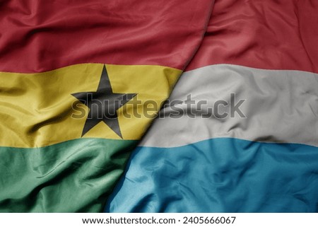 big waving national colorful flag of luxembourg and national flag of ghana . macro