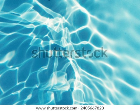 Closeup​ blur​ abstract​ of​ surface​ blue​ water. Abstract​ of​ surface​ blue​ water​ reflected​ with​ sunlight​ for​ background.Top​ view​ of blue​.