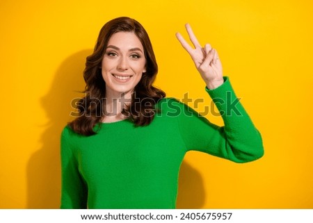 Portrait of stunning positive person beaming smile hand fingers demonstrate v-sign isolated on yellow color background