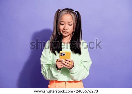 Photo of a girl with tails korean blogger thinking about boost her stats in instagram using smartphone isolated on purple color background