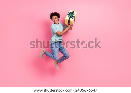 Full body photo of attractive young man running hold big giftbox celebration wear trendy blue clothes isolated on pink color background