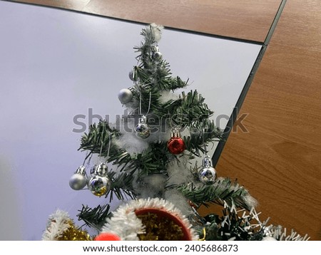 Mini artificial Christmas Tree decoration at home. Isolated on white and pallete like background.