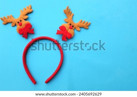 cute Christmas headbands with christmas reindeer horns isolate on a blue backdrop. concept of joyful Christmas party,New year is coming soon, festive season decoration with Christmas elements