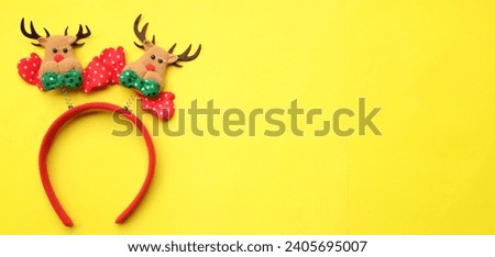 cute Christmas headbands with christmas reindeer horns isolate on a yellow backdrop. concept of joyful Christmas party,New year is coming soon, festive season decoration with Christmas elements