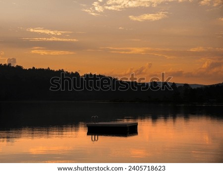 Swimming dock in lake or pond in New Hampshire at sunset