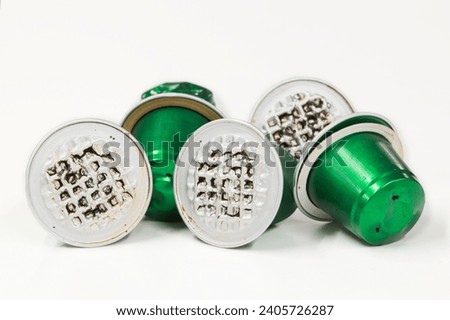 Used green aluminum espresso coffee pods single use cups, isolated on a white background with copy space. Royalty-Free Stock Photo #2405726287