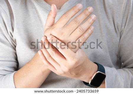 Hand of man she massages his thumb and has finger pain, locked finger from work and office syndrome. on a white background medical concept