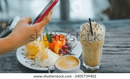 Hand holding smartphone touching screen and taking food photography for social network. Social Media Trends For Business concepts.