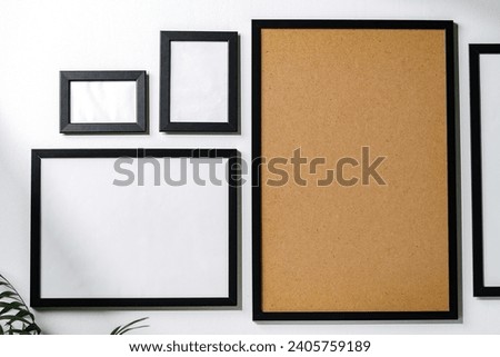 Set of black frames on white wall with copy space