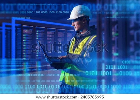 Man system administrator. Engineer with laptop stands in server room. System administrator among binary code. Man master in setting up hosting equipment. System administrator at hardhat