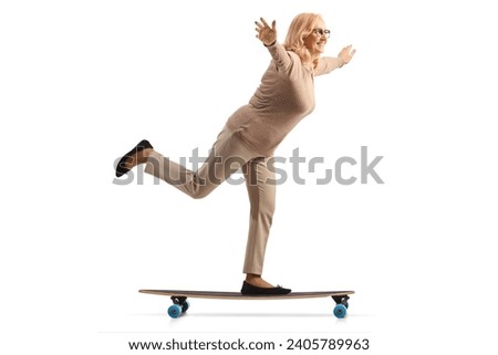 Middle aged woman riding a skateboard and spreading arms isolated on white background