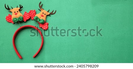 cute Christmas headbands with christmas reindeer horns isolate on a greeen backdrop. concept of joyful Christmas party,New year is coming soon, festive season decoration with Christmas elements