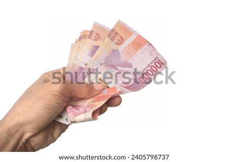 Indonesia 12 28 2023. hand holding money on white background. business finance