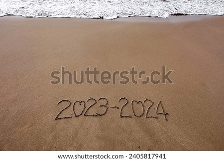 Happy New Year ,2023- 2024, lettering on the beach with wave