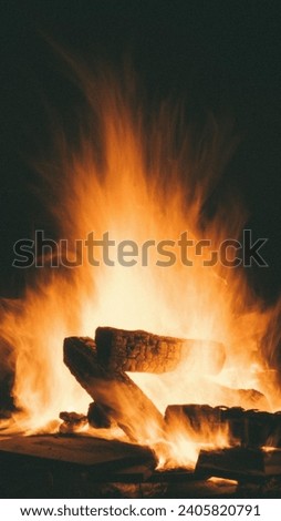 A picture of a glowing fire burning from wood, with a warm and calm view in the middle of the cold winter