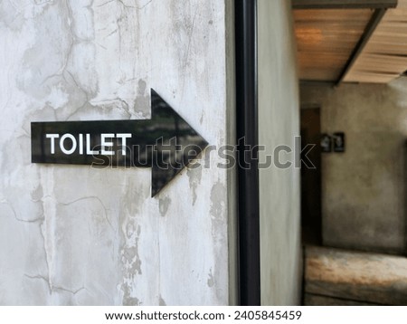 black arrow pointin toilet sign 