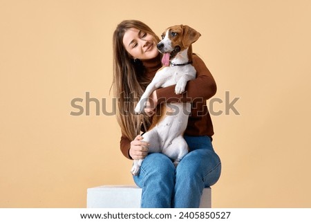 Portrait of cute Beagle on hands of attractive happy smiling young woman. Love and friendship between dog and human. Concept of animal, pet lover, dogfriendly, domestic life, companionship. Royalty-Free Stock Photo #2405850527