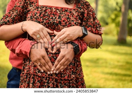 Indian couple posing for Maternity shoot pose for welcoming new born baby in Lodhi Road in Delhi India, Maternity photo shoot done by parents for welcoming their child, Pre Baby Photo Shoot Royalty-Free Stock Photo #2405853847