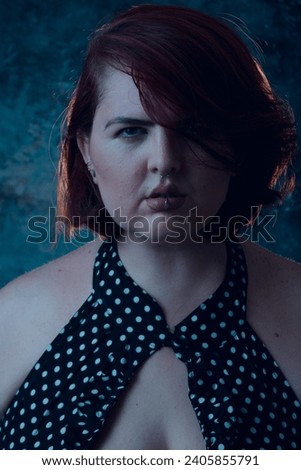 Vertical portrait of young plus size Latina with short hair, light eyes and white skin, looking at camera seriously, close-up, image for social networks.