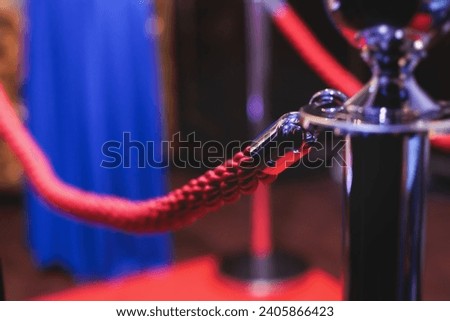 Red carpet with ropes and golden barriers on a luxury party entrance, cinema premiere film festival event award gala ceremony, wealthy rich guests arriving, outdoor decoration elements, summer day Royalty-Free Stock Photo #2405866423
