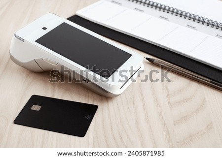 payment terminal and bank card on a light wooden background, online payment