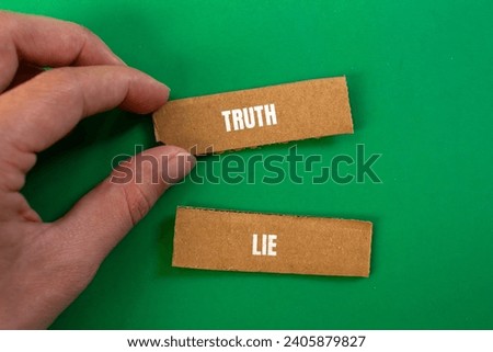 Truth or lie lettering on ripped cardboard paper with green background. Conceptual photo. Top view, copy space.