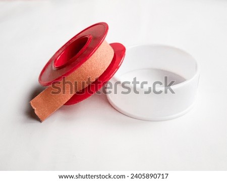 wound tape or rolled wound plaster in brown color on a white background