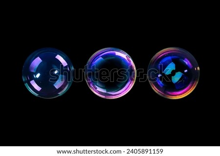 BUBBLES ISOLATED ON BLACK BACKGROUND, LIGHT GLOWING SOAPY RAINBOW SPHERES ON DARK Royalty-Free Stock Photo #2405891159