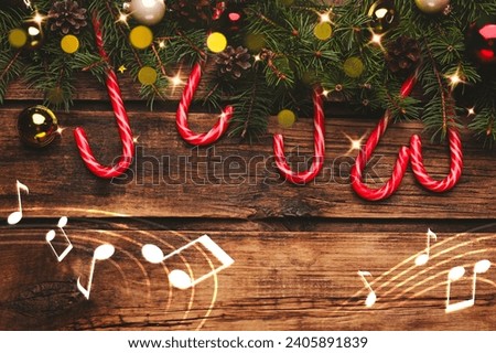 Music notes and wooden table with fir branches and festive decor, top view. Christmas and New Year melody