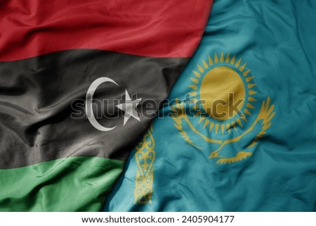 big waving national colorful flag of kazakhstan and national flag of libya . macro