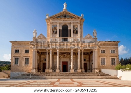 Stunning church facade with ornate Corinthian columns, sacred statues, and vivid mosaics under a pristine blue sky